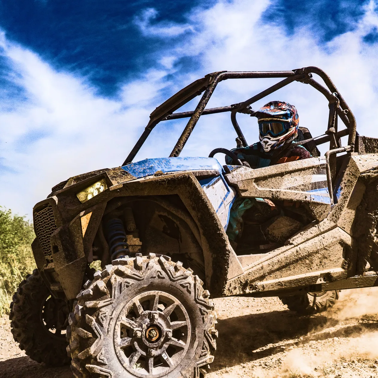 UTV driving off-road under a blue sky